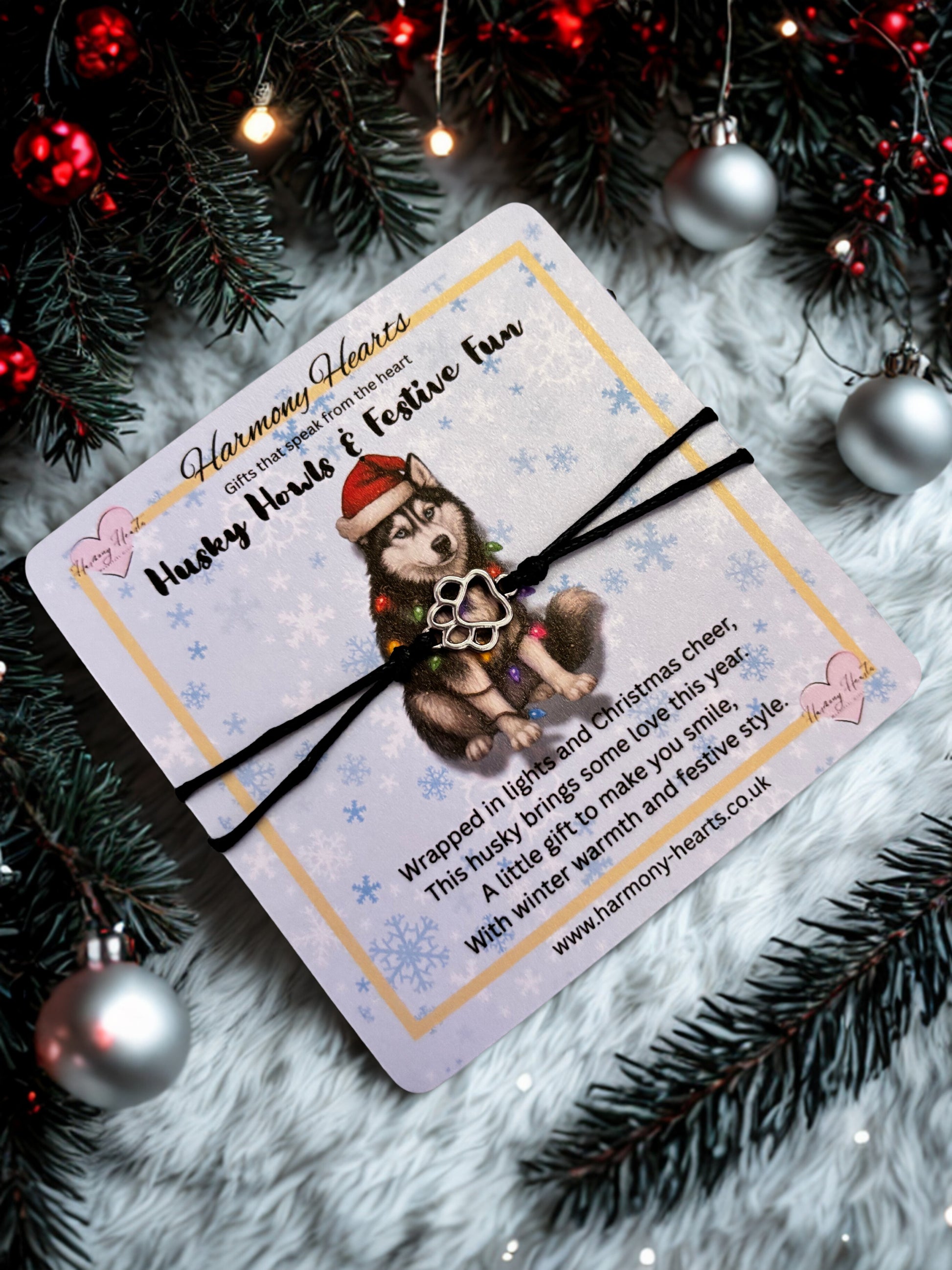 Gift card with a husky design and bracelet on a festive background with Christmas decorations.