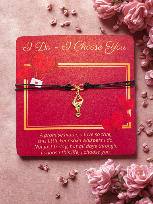 Gold charm on a red card with romantic text, surrounded by pink flowers on a pink background