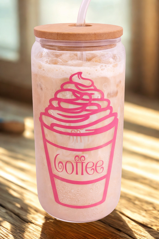 Glass tumbler with wooden lid and straw, featuring a coffee cup design, on a wooden surface.