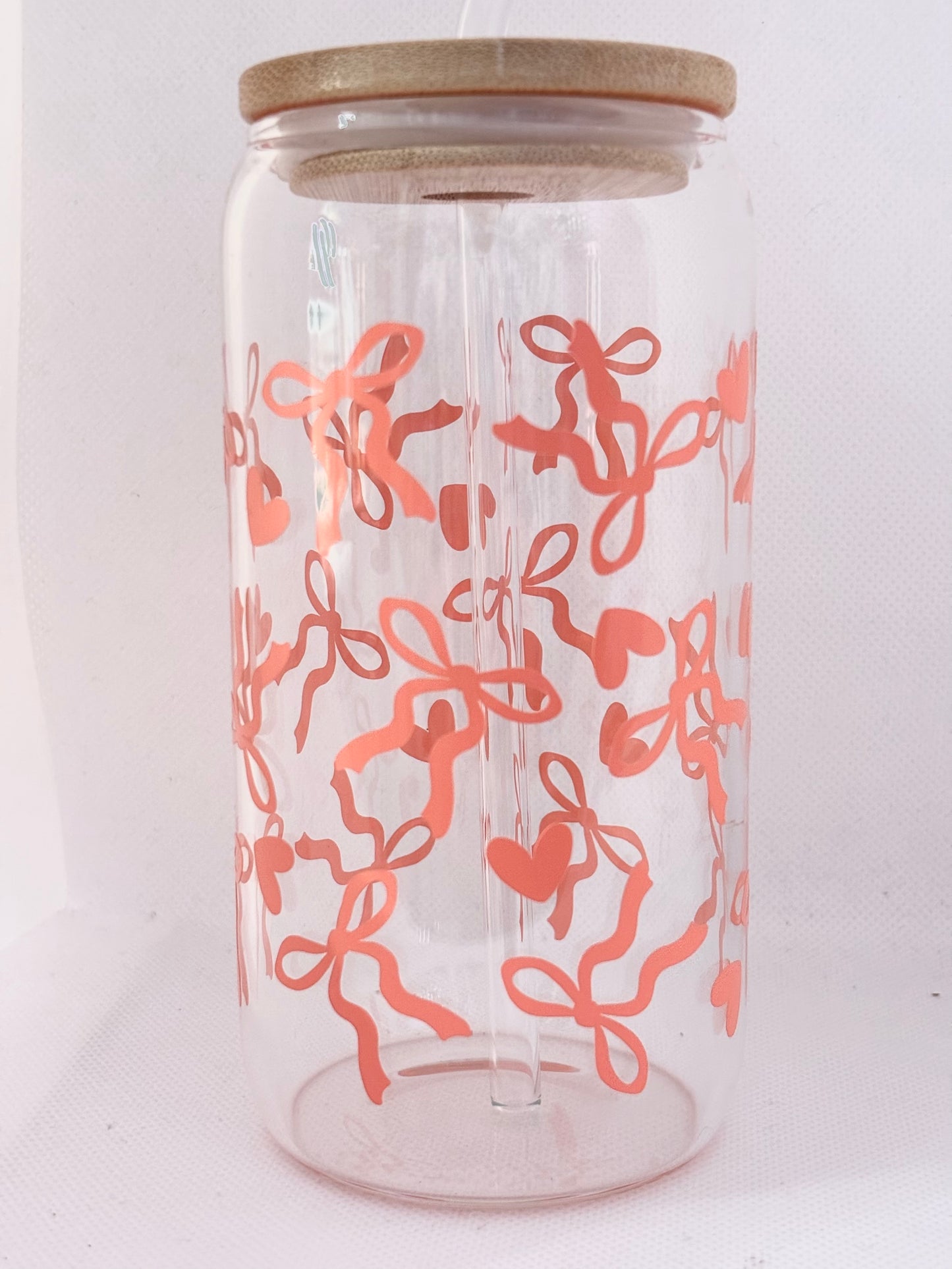 Clear glass  with coral pink bows  and hearts pattern and wooden lid on a white background