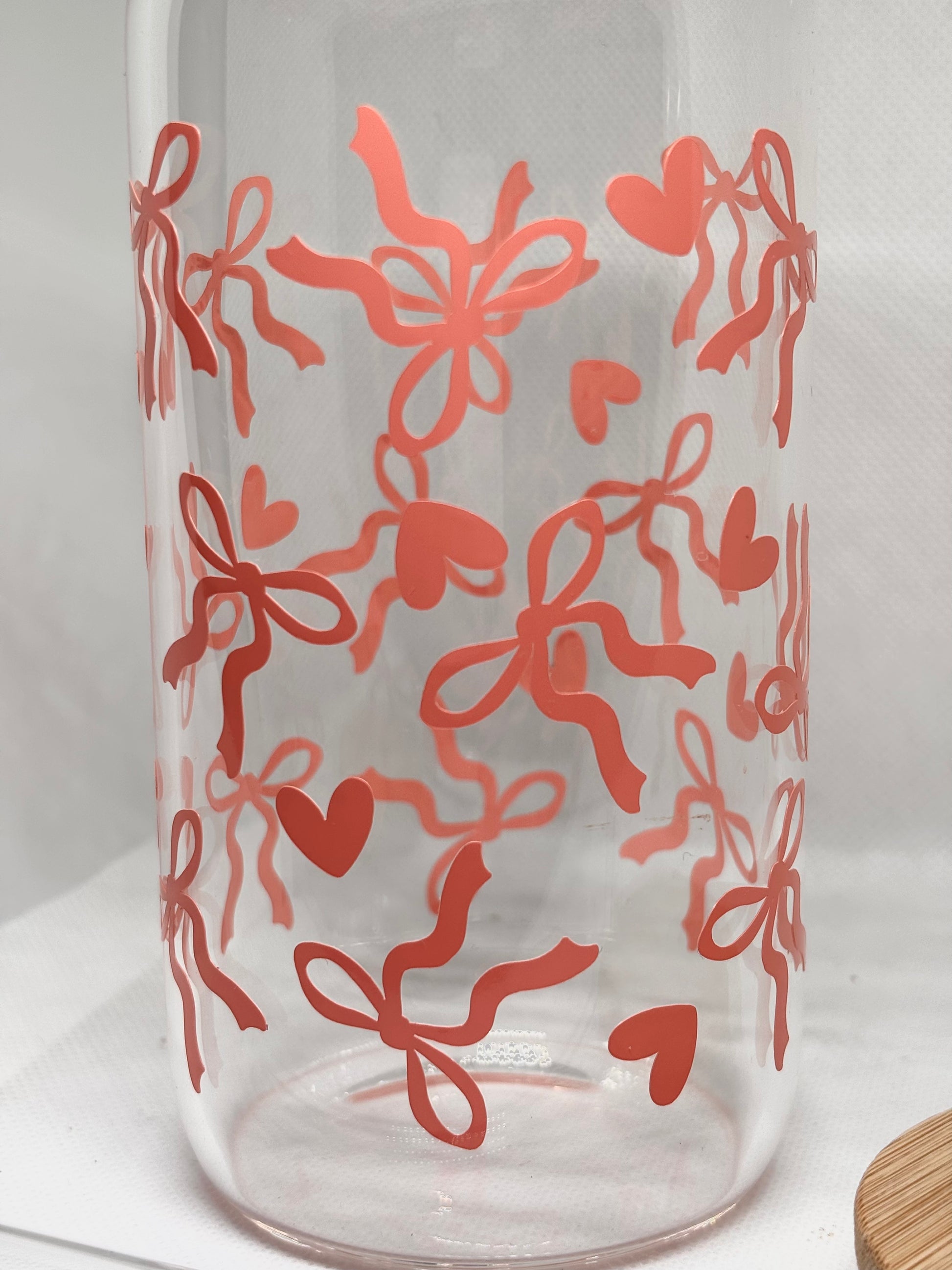 Clear glass with coral bows and heart patterns on a white background
