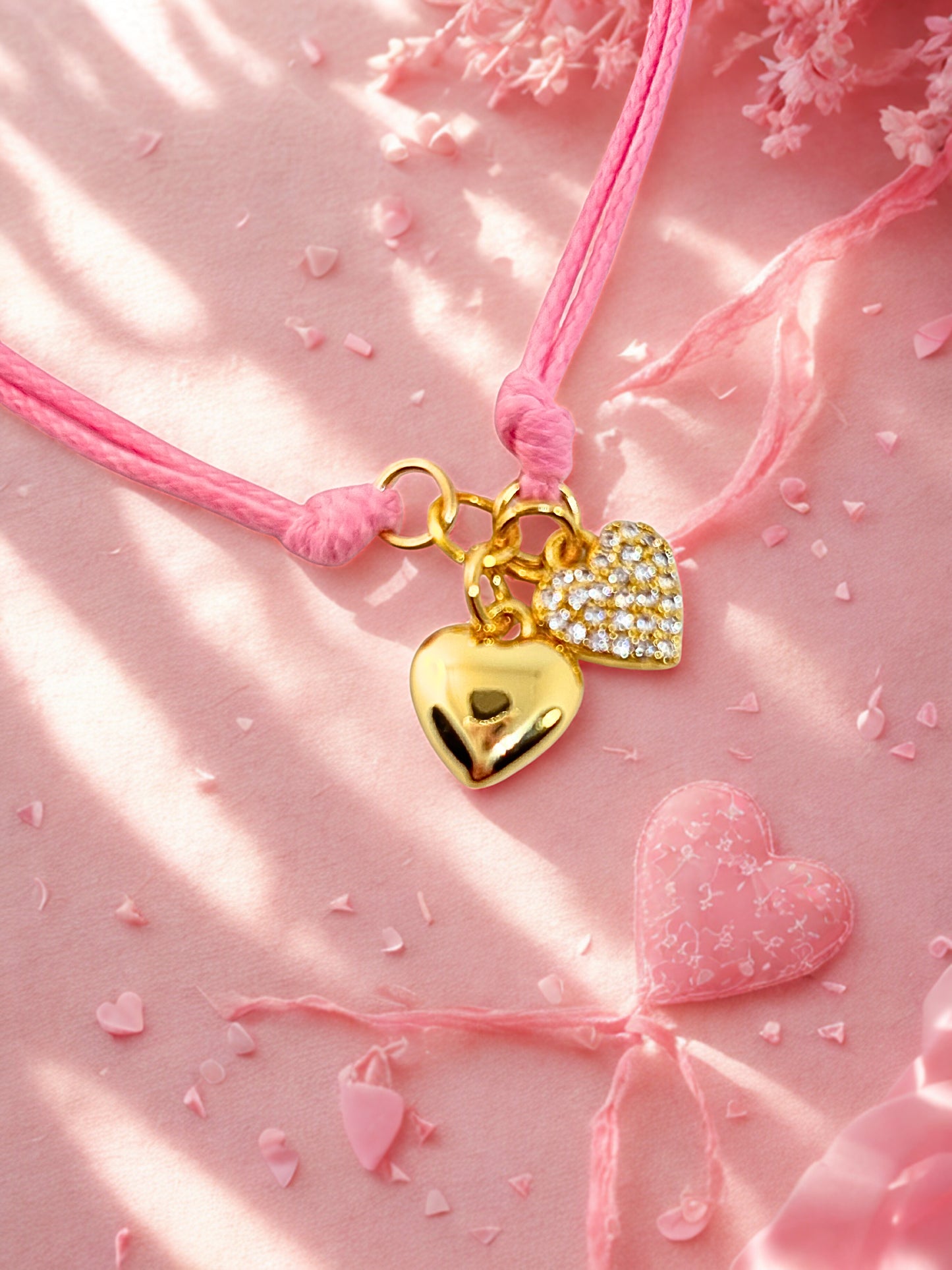 bracelet with heart-shaped charms on a pink background