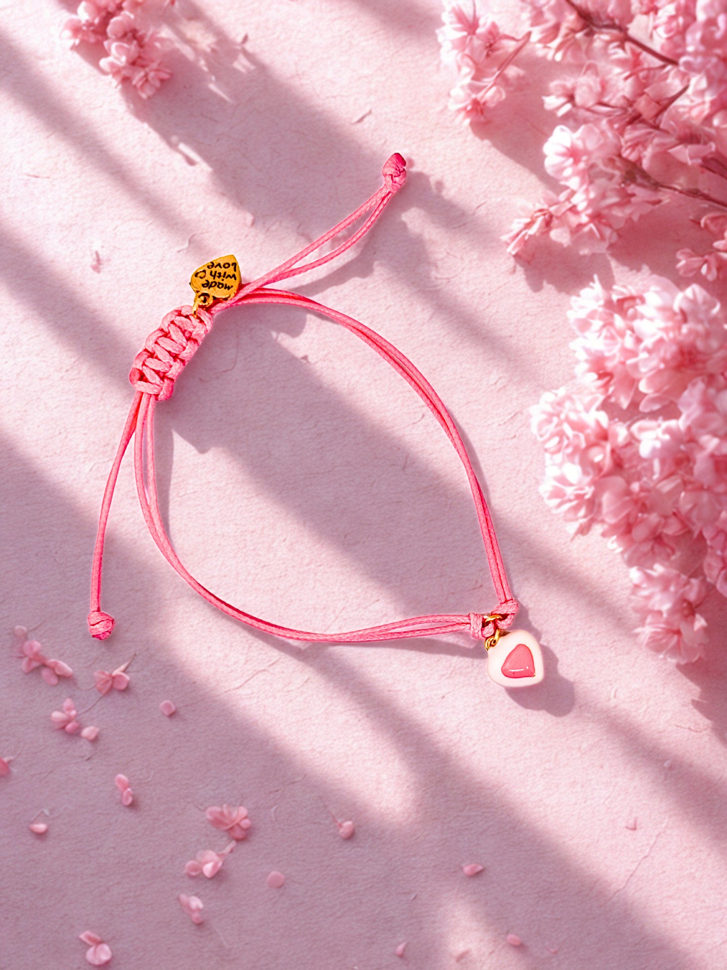 Pink enamel heart charm on a soft pink cord bracelet