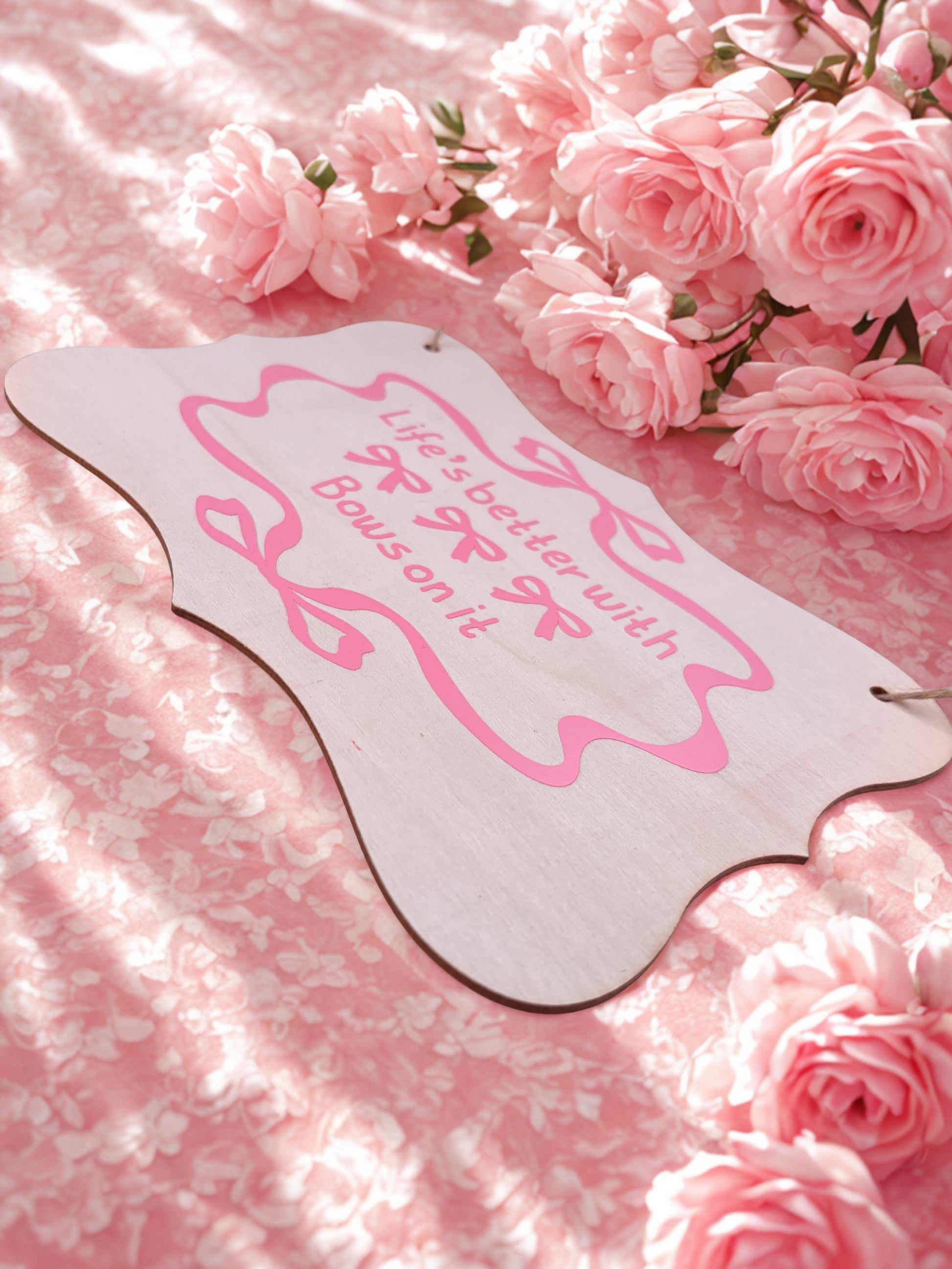 Decorative sign with pink text on a pink floral background