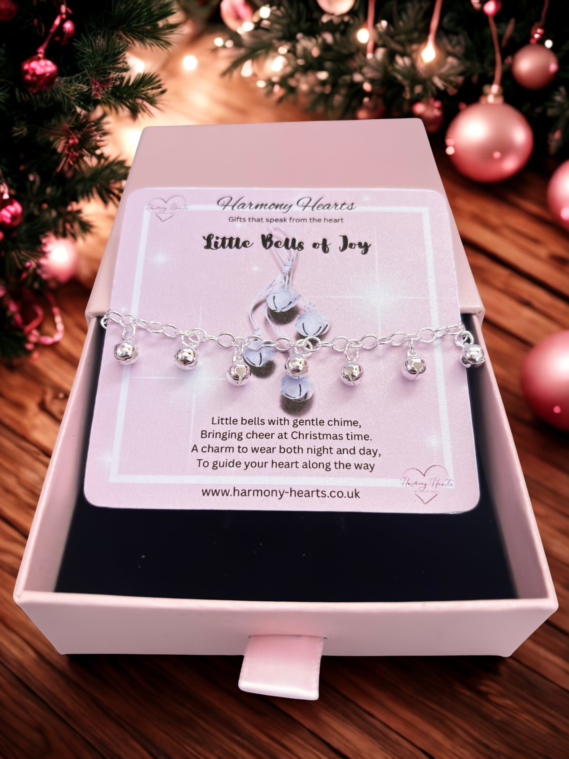 Bracelet with charms in a pink box against a festive background
