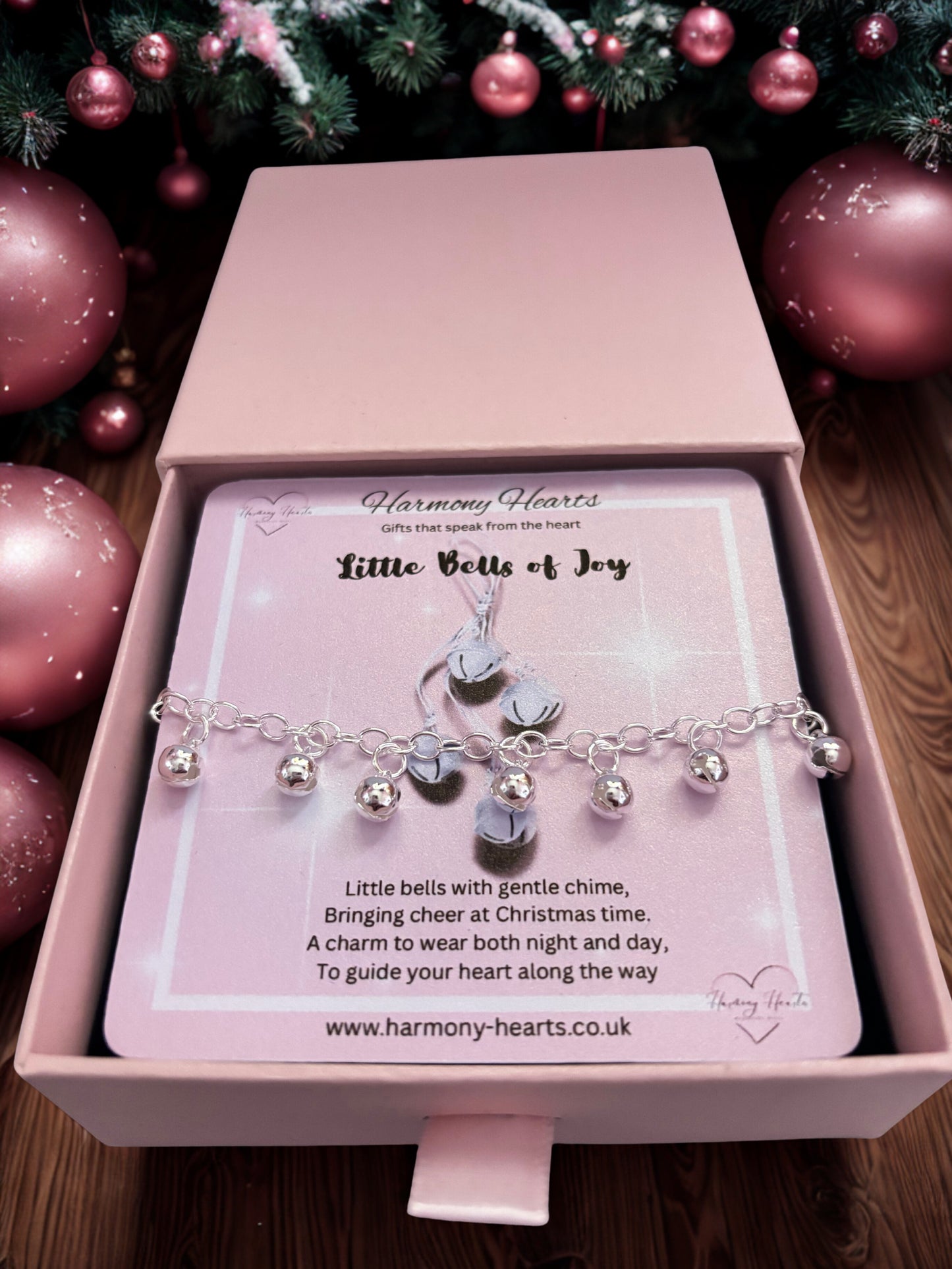 Bracelet with charms in a pink box with a Christmas-themed background