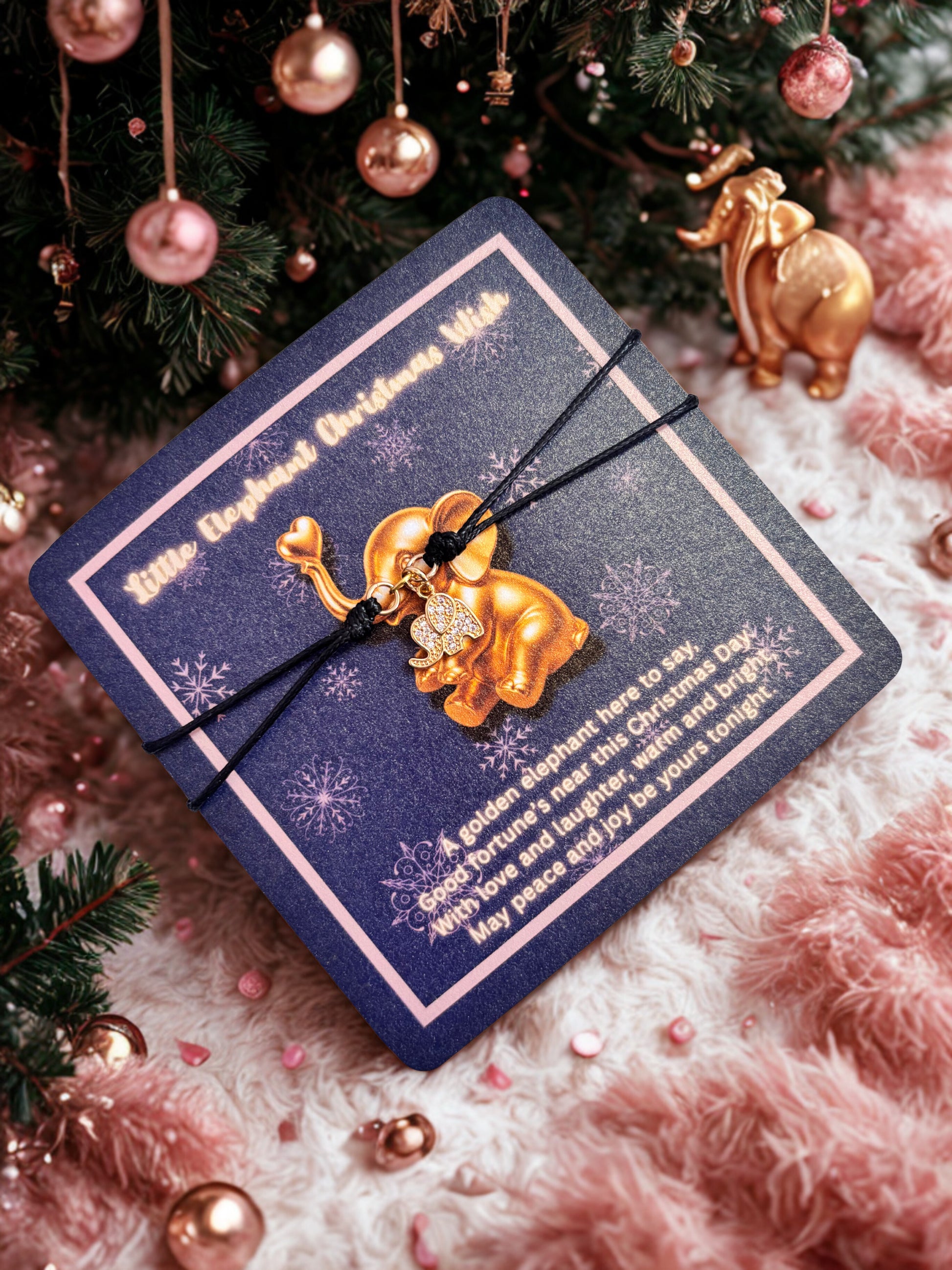 Gold elephant charm bracelet on a blue card with Christmas decorations in the background