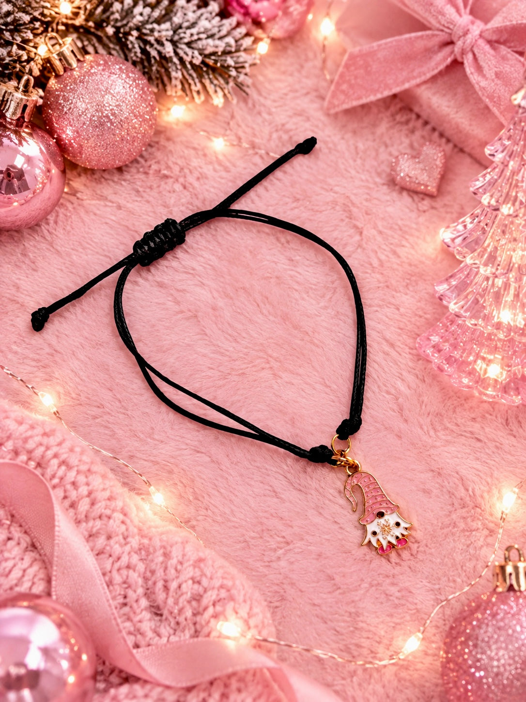 Black cord charm bracelet with a pink gonk charm set on a pink festive background