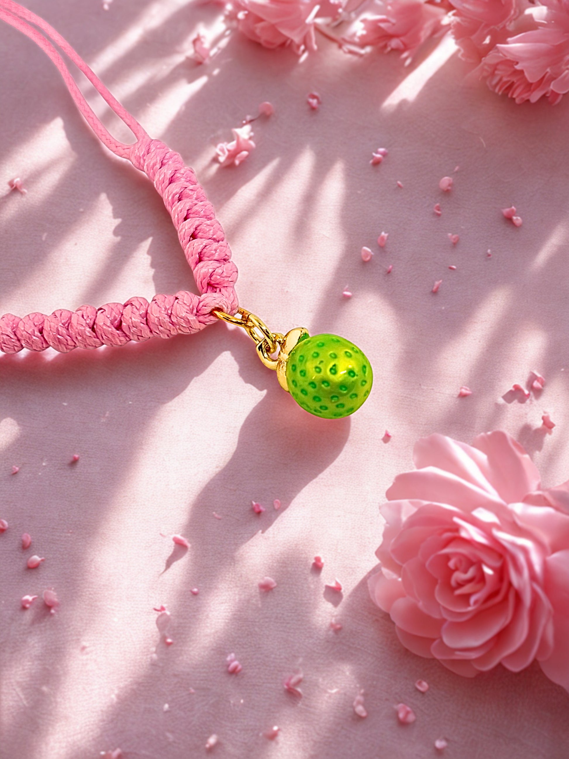 Pink cord bracelet with a lime charm