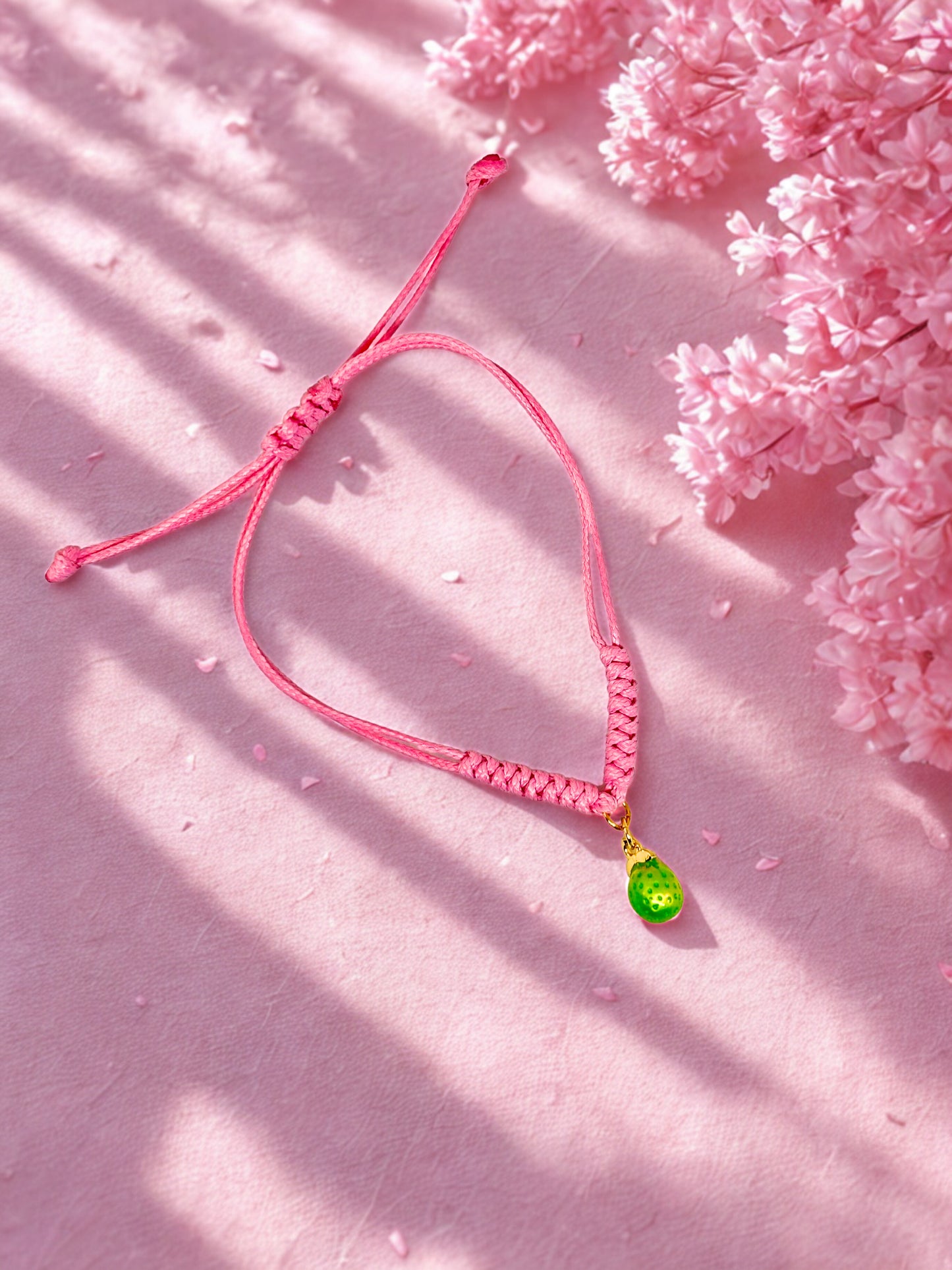 Pink cord bracelet with a lime charm