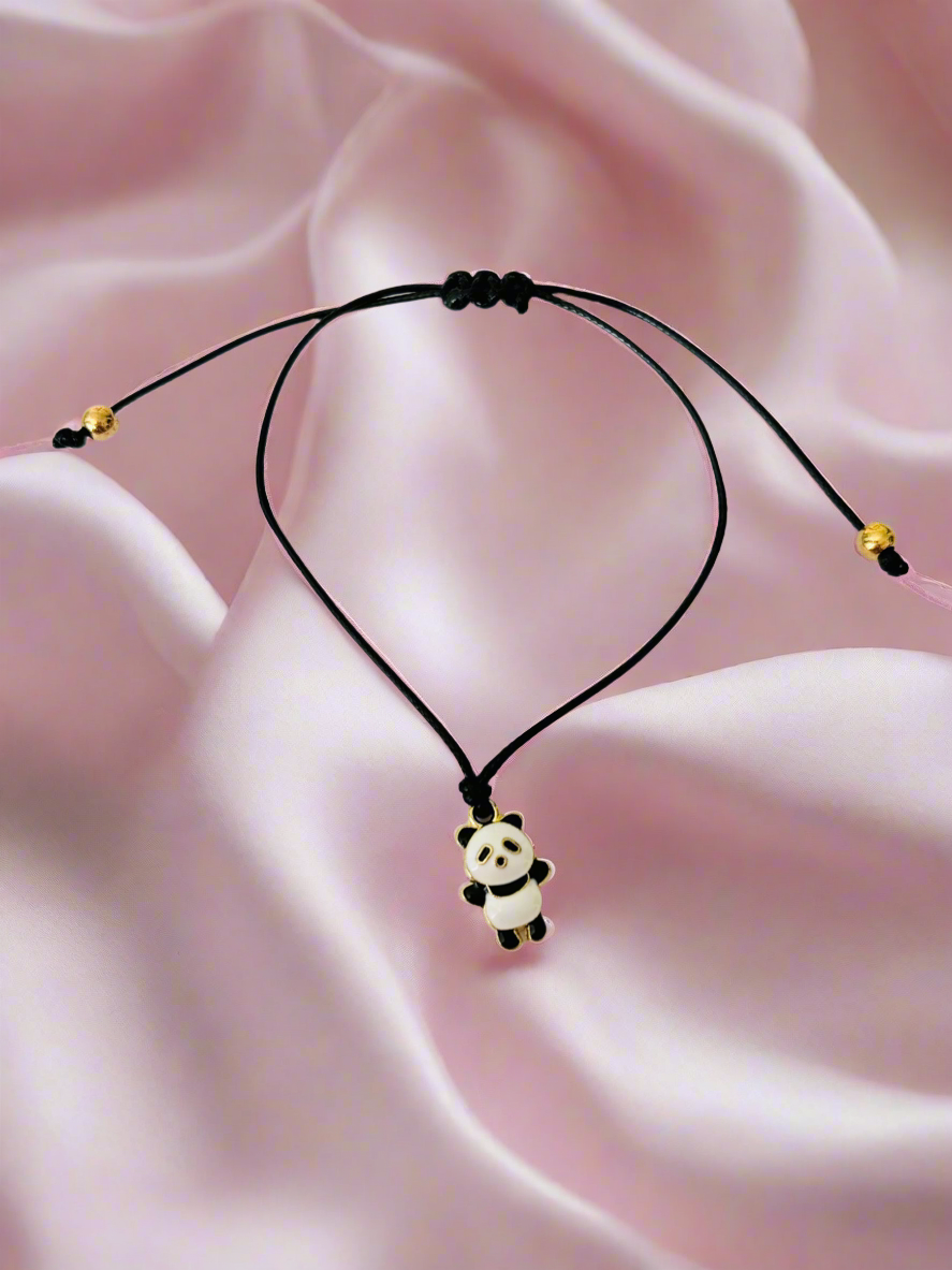 Bracelet with a panda pendant on a pink fabric background