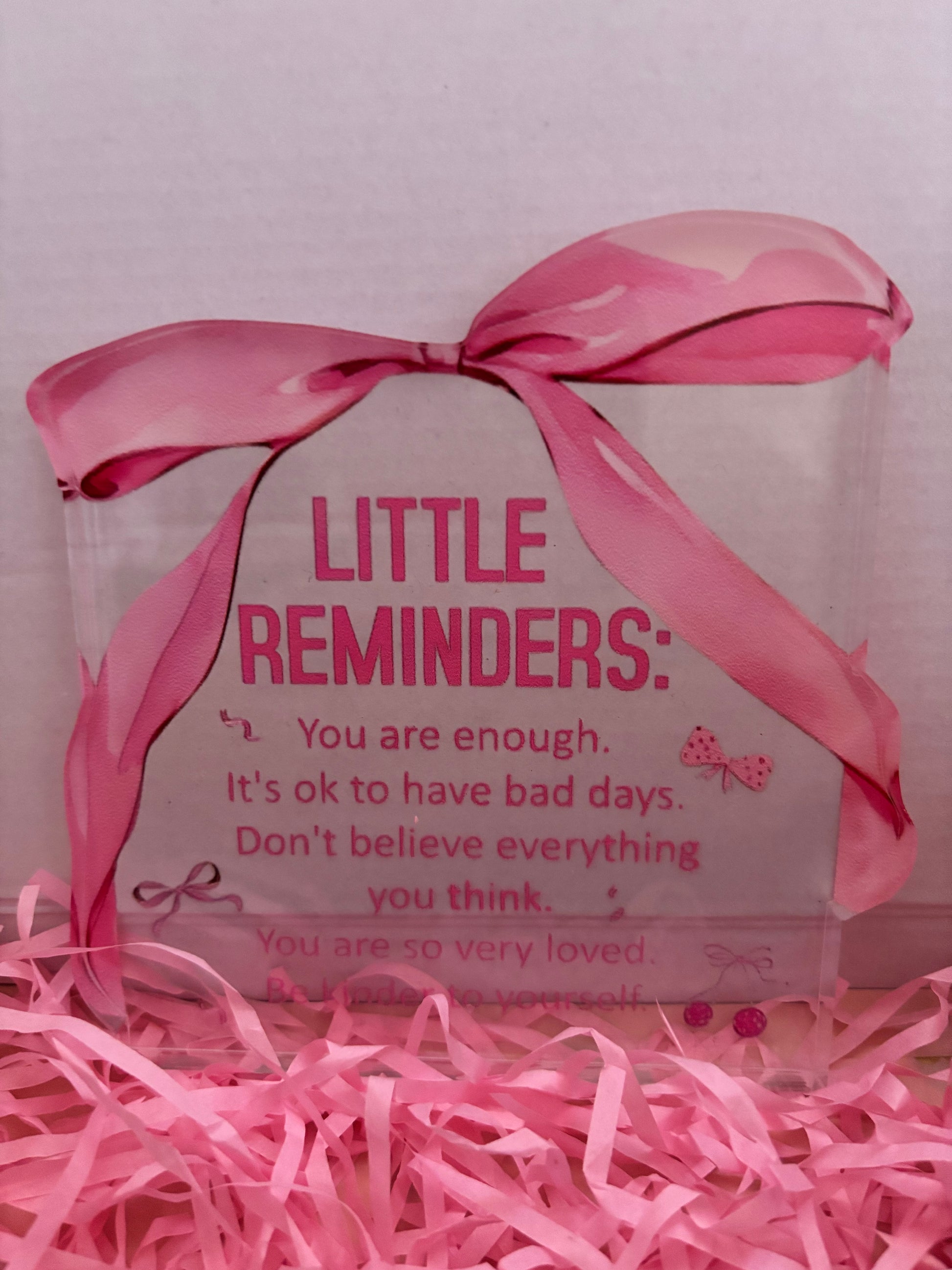 Decorative box with pink ribbon and motivational message on a pink background
