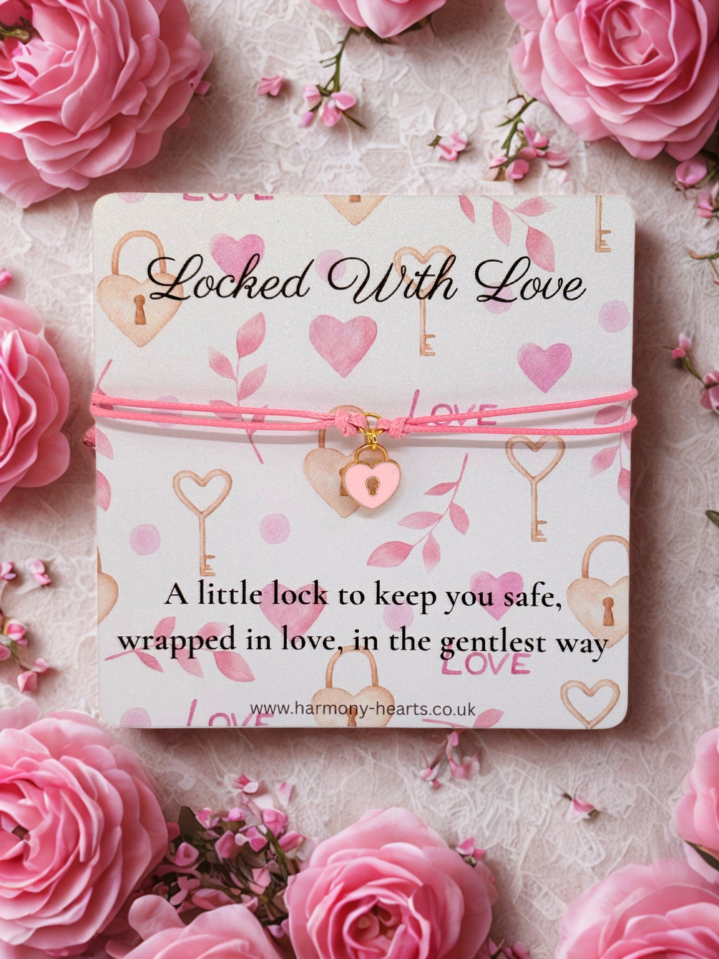 Pink charm bracelet with padlock charm on a  'Locked With Love' text illustrated card surrounded by pink roses