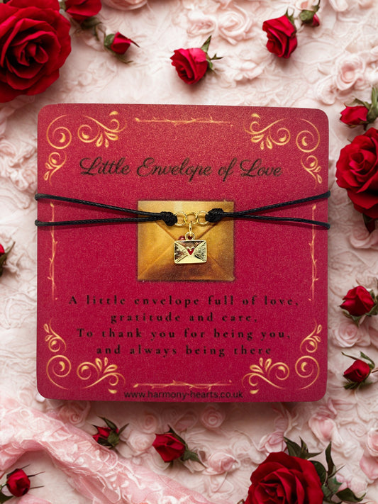 Red card with gold envelope charm and rose petals on a floral background