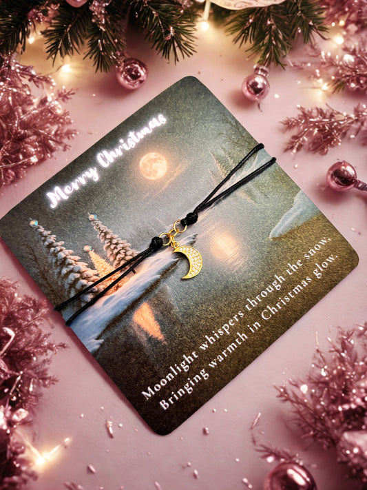 Card with Christmas scene and gold moon charm bracelet on a festive background