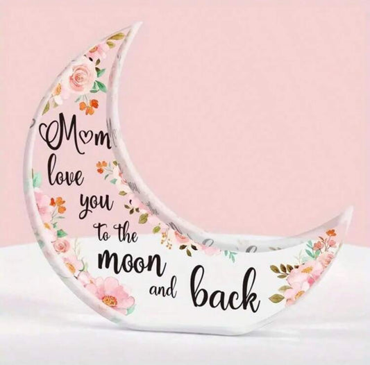 A crescent-shaped acrylic plaque with a floral pattern and the text 'Mum, love you to the moon and back' written on it.