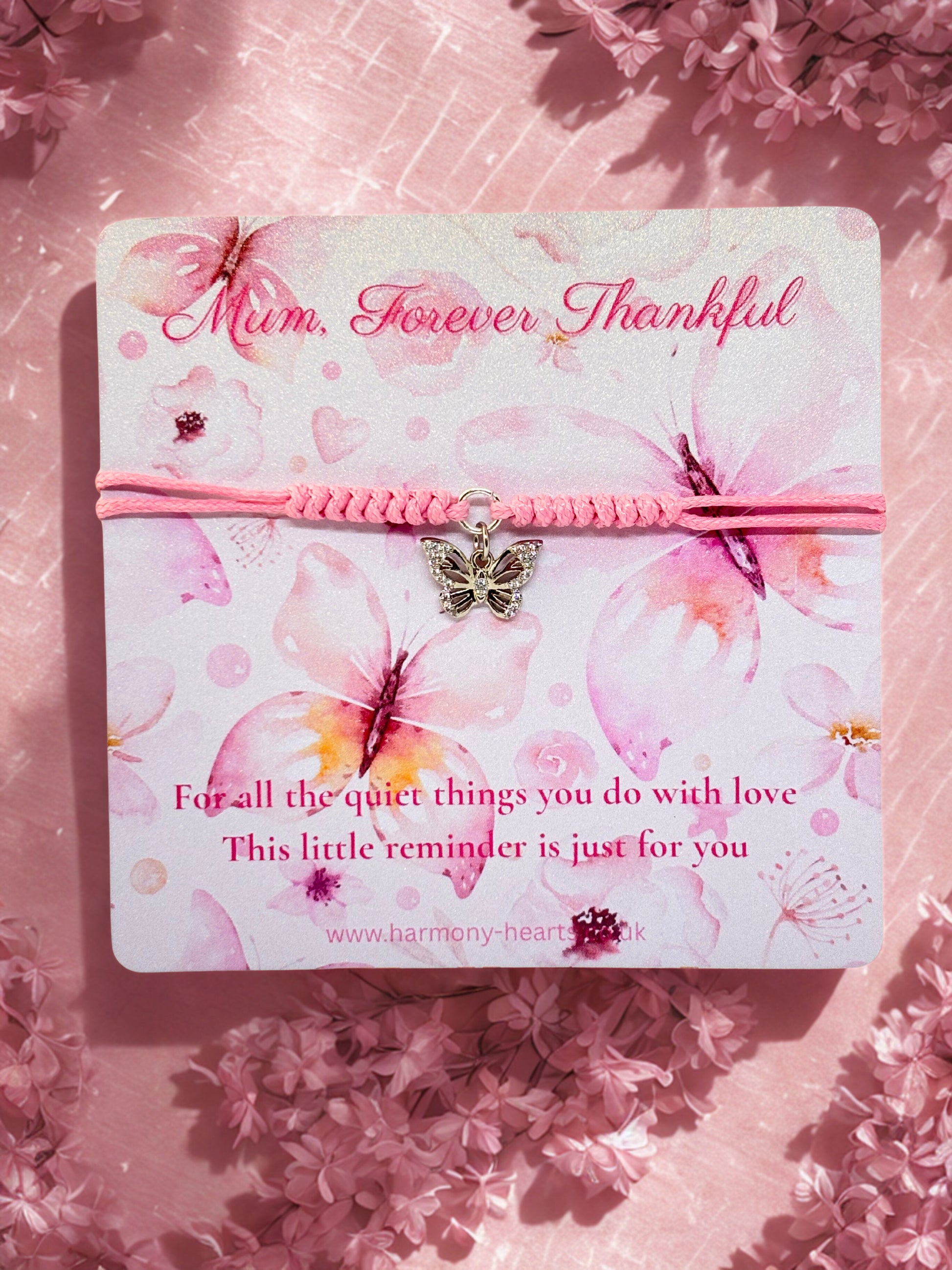 Pink bracelet with butterfly charm on a floral card with 'Mum, Forever Thankful' text.