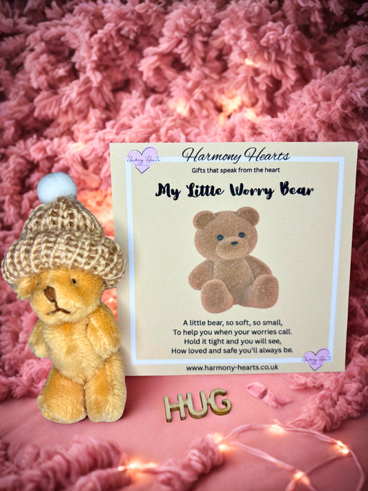 Teddy bear with a hat next to a card on a pink textured background