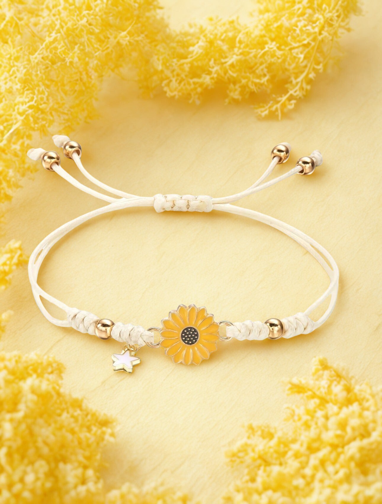 White bracelet with sunflower charm on a yellow textured background