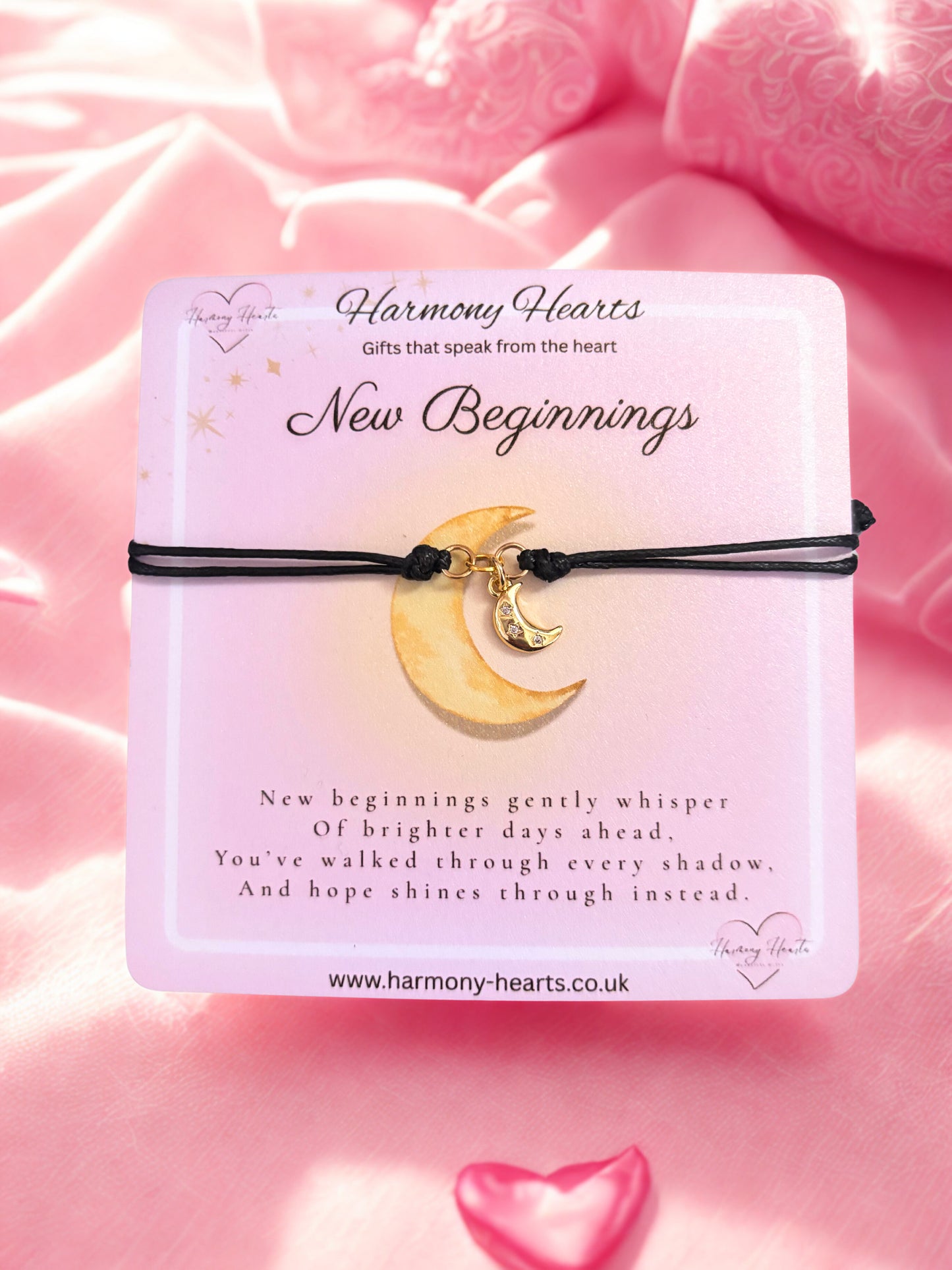 Bracelet with moon charm on a pink background, featuring 'Harmony Hearts' branding.