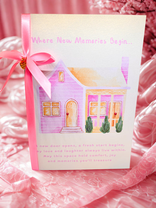 Greeting Card New Home with a house illustration and pink ribbon on a pink fabric background