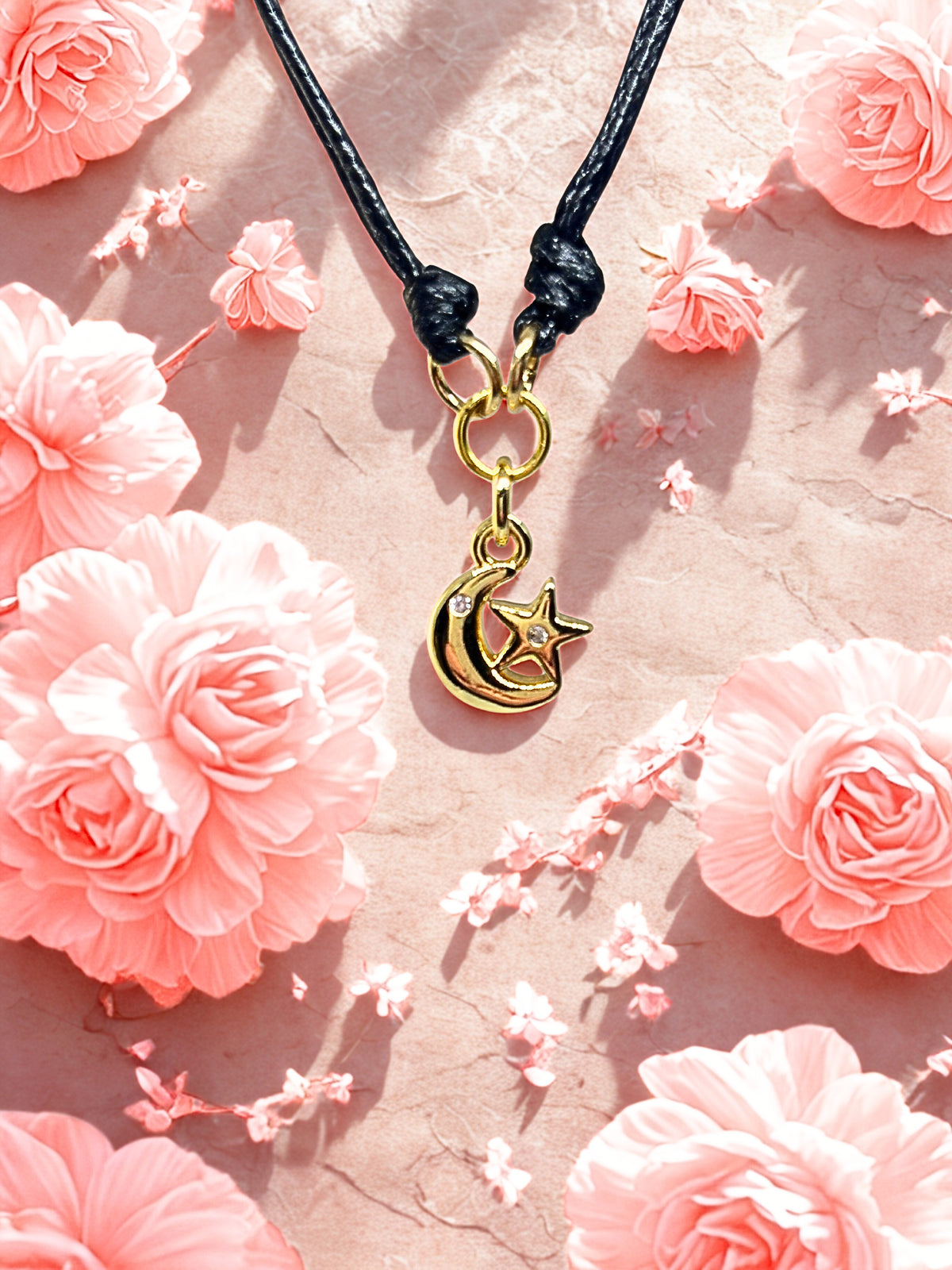 Bracelet with a gold moon and star charm on a pink floral background