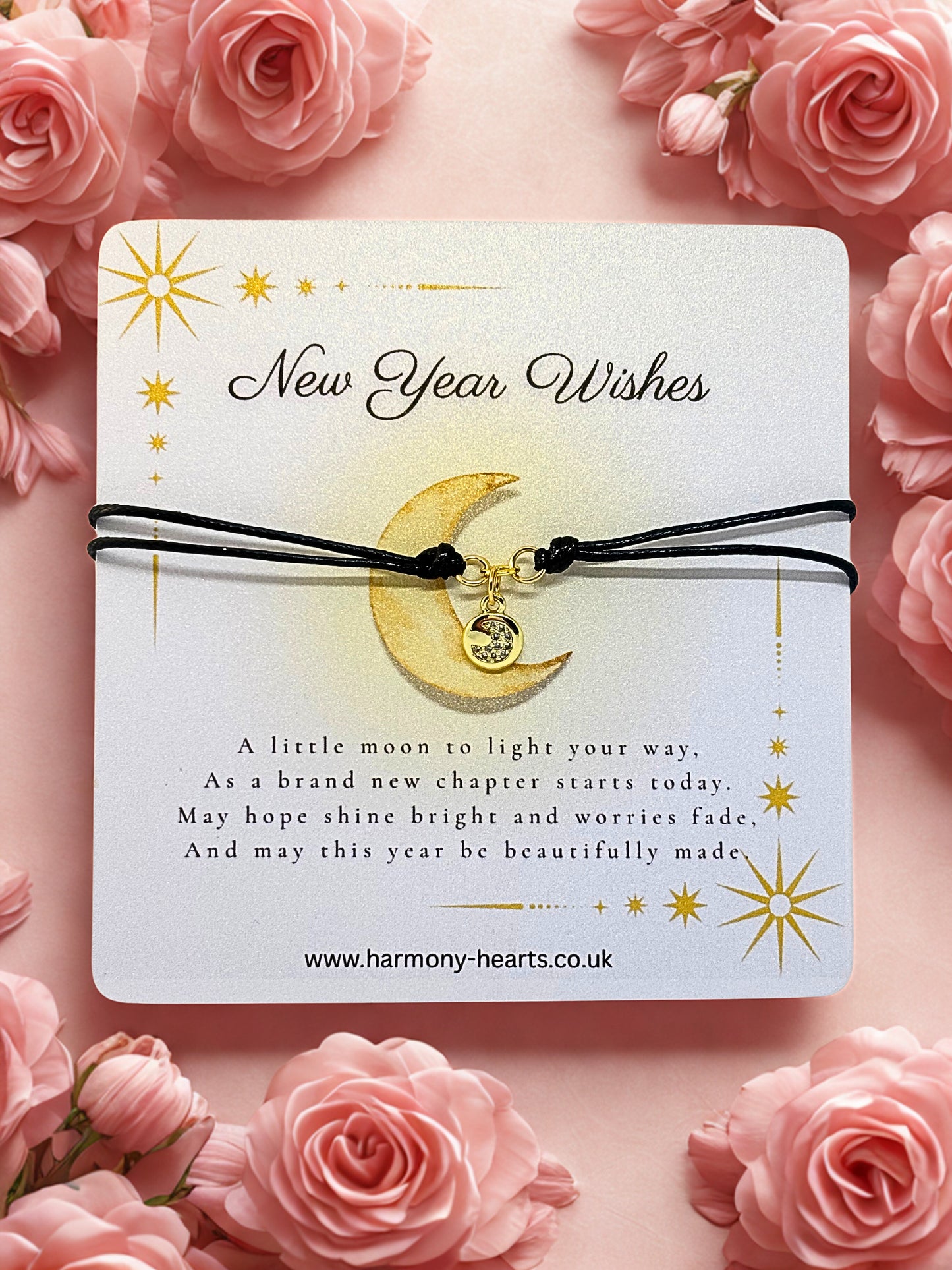 Jewelry card with moon charm on a pink floral background, featuring 'New Year Wishes' text.