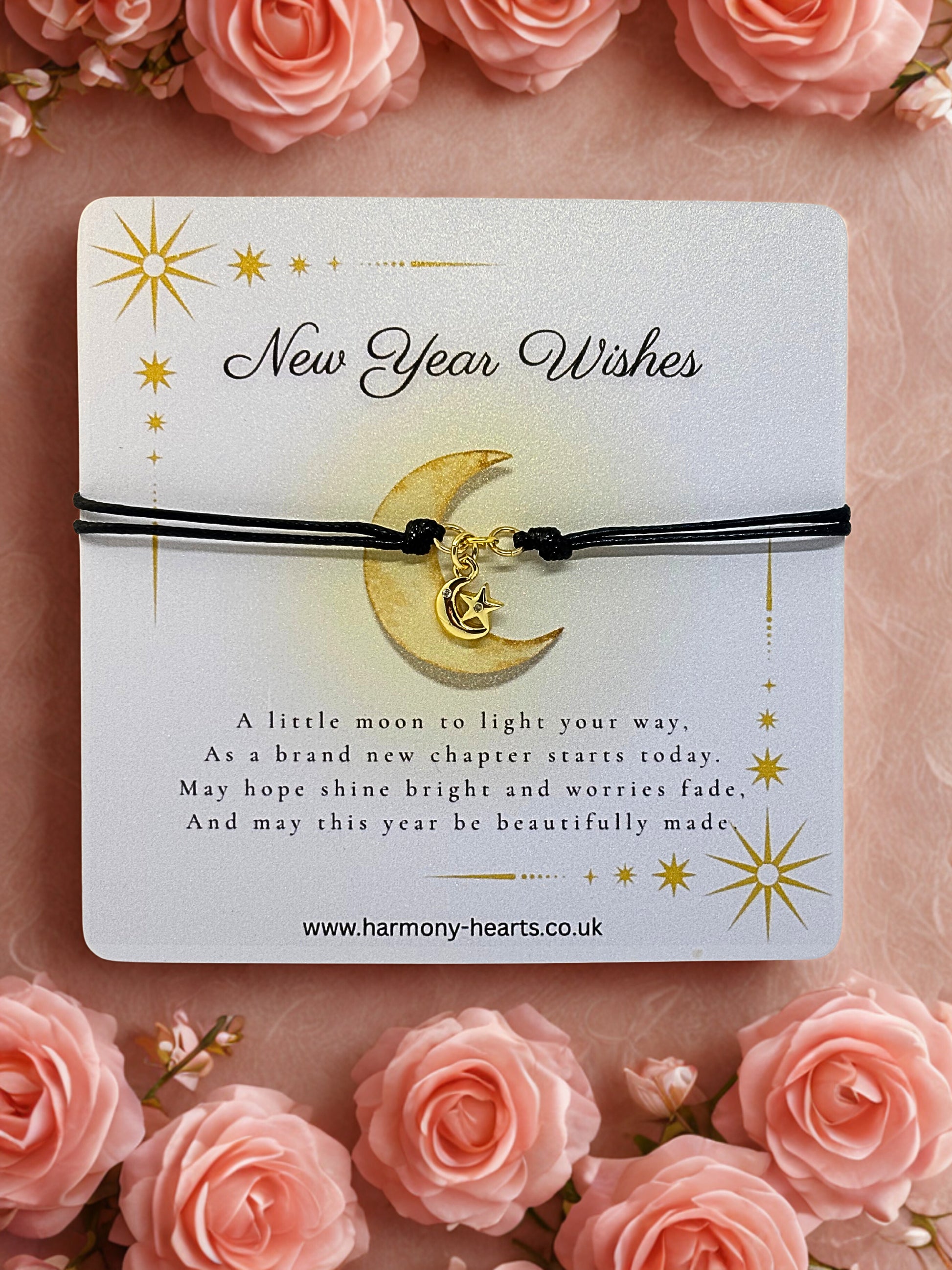 New Year wishes card with a moon charm on a pink background with roses