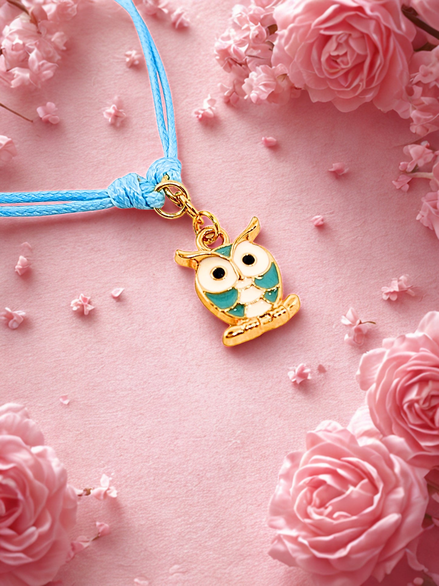 Bracelet with an owl charm on a pink floral background