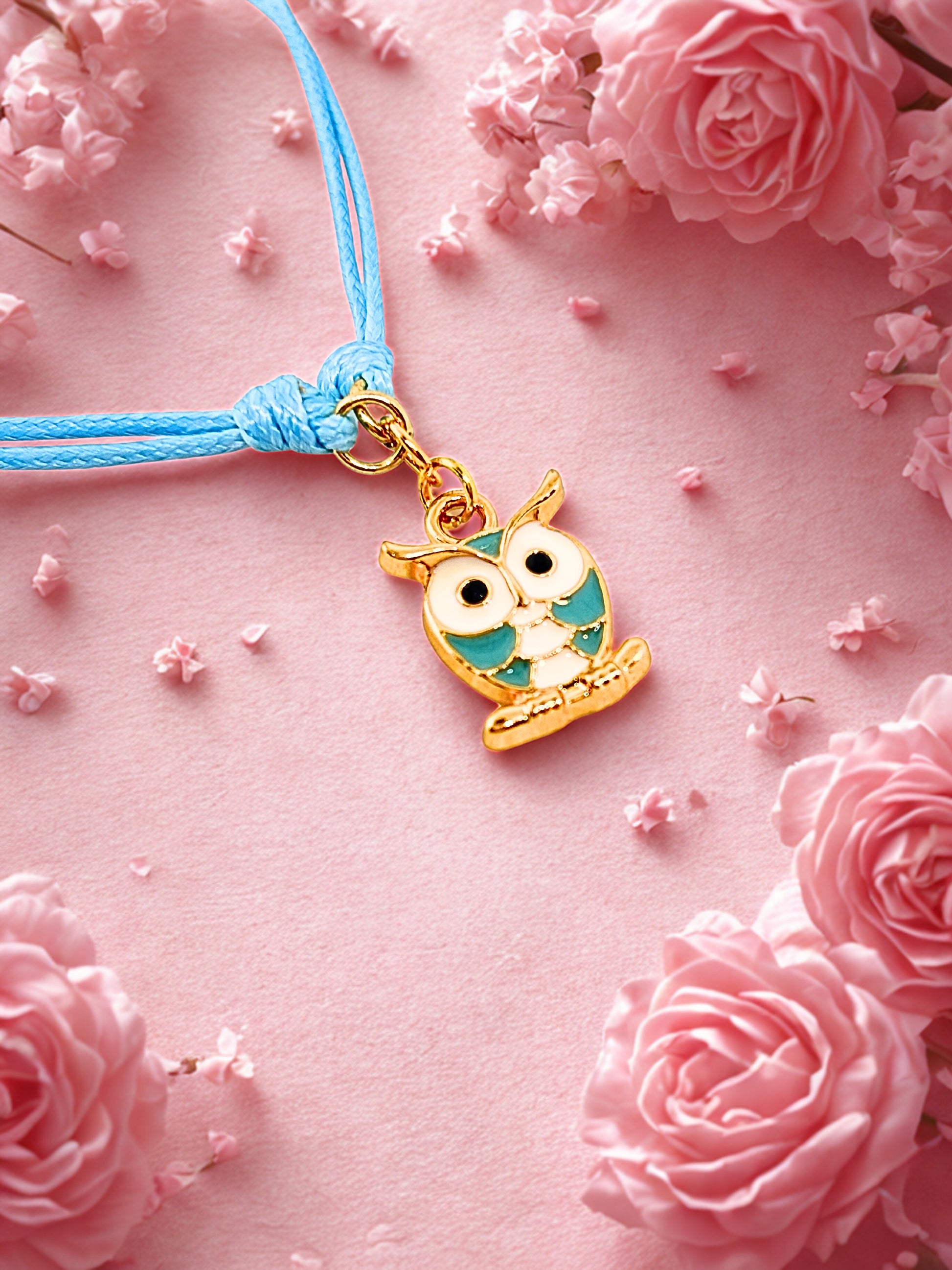 Bracelet with an owl charm on a pink floral background