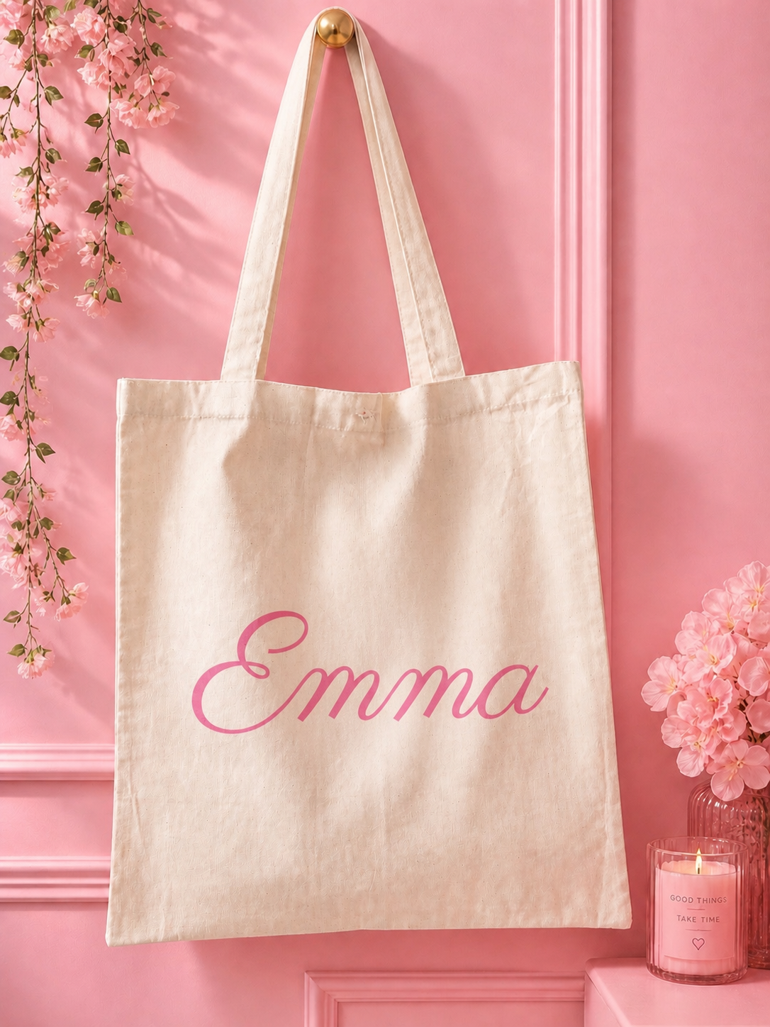 Beige tote bag with 'Emma' in pink text on a pink background with decorative elements.