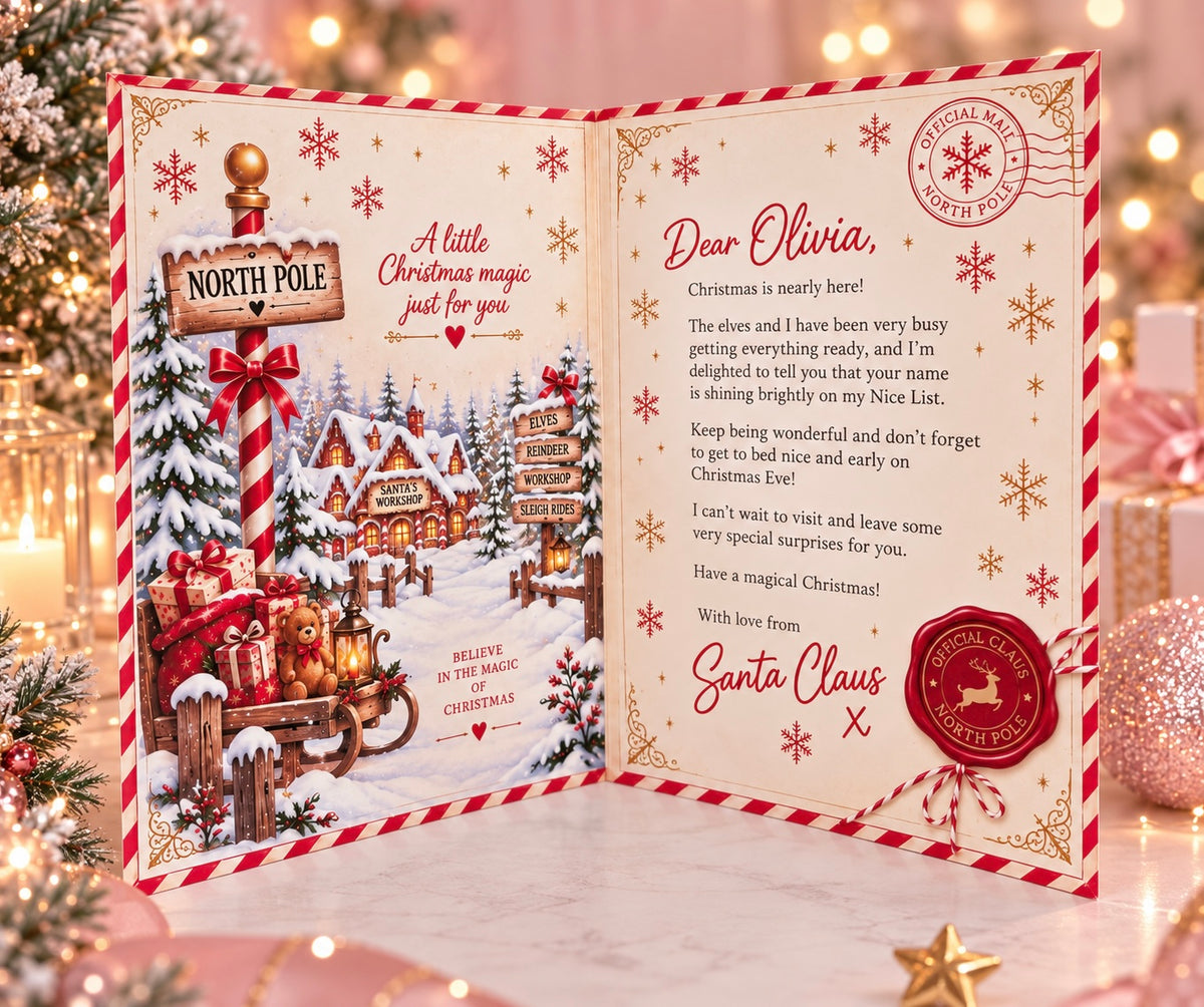 An open Christmas greeting card displayed on a marble surface with holiday lights and a tree in the background. The card features a festive red-and-white border, a winter village illustration on the left panel, a poem addressed to Olivia on the right panel, and Santa Claus branding with a red seal.