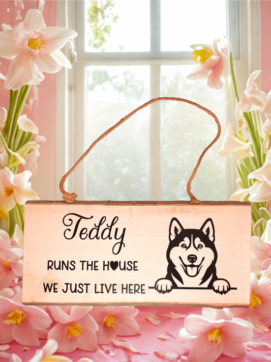 Wooden sign with a dog illustration and personalised text, surrounded by flowers