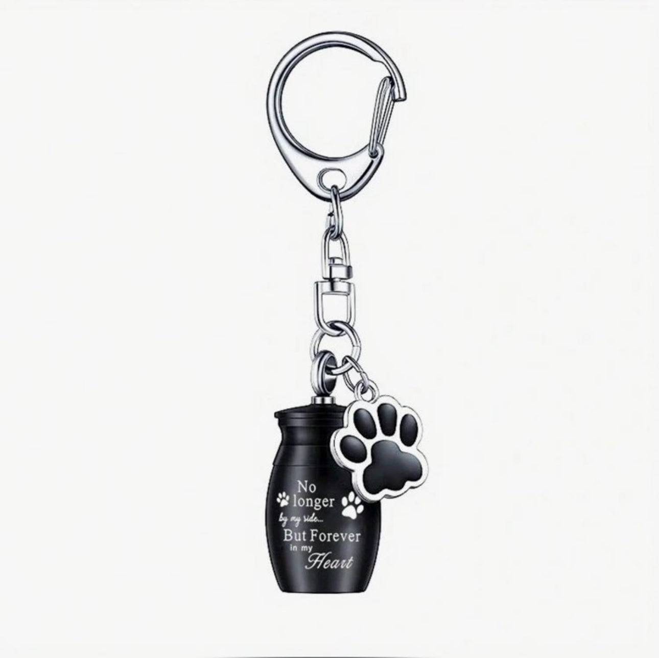 A stainless steel keyring featuring a mini urn charm with an engraved quote and a paw print charm attached to a black keychain.