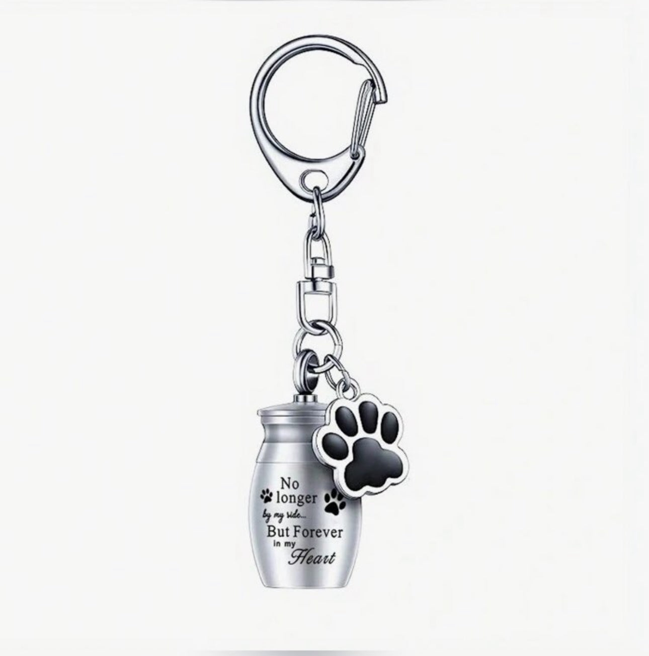 A stainless steel keyring featuring a mini urn charm with an engraved quote and a paw print charm attached to a black keychain.