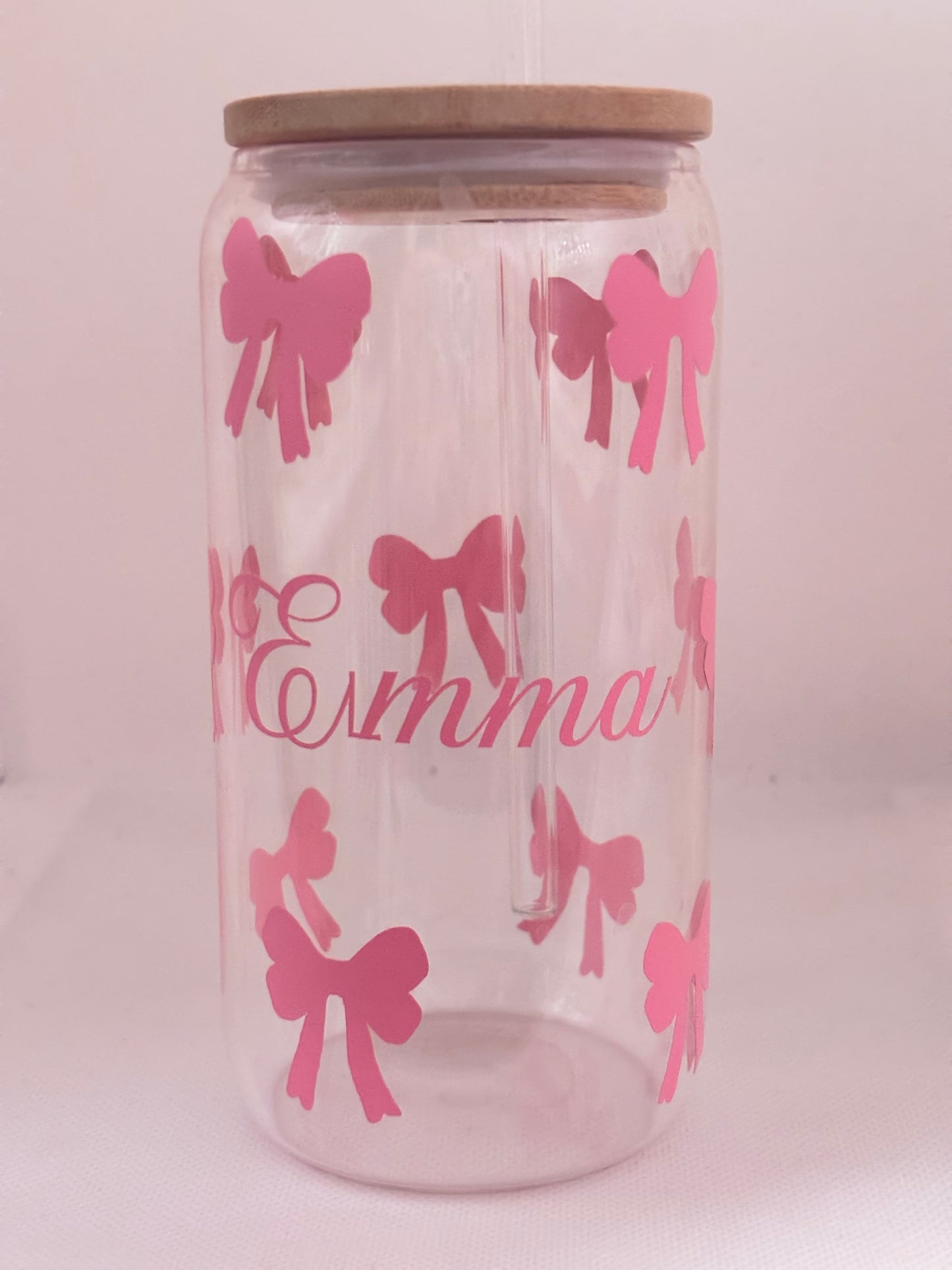 Clear glass with pink bows and the name 'Emma' on a light pink background