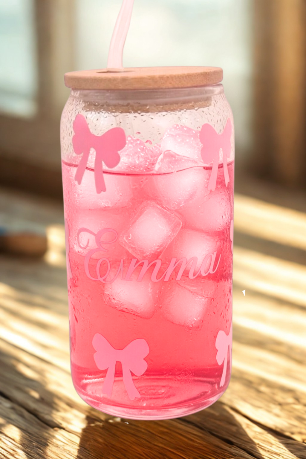 Glass filled with pink lemonade with pink bows and the name Emma