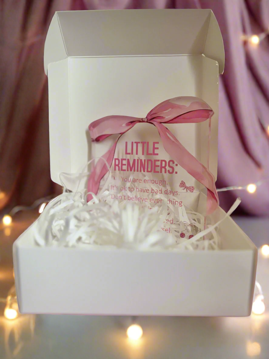 Gift box with a pink bow and 'Little Reminders' message on a pink background