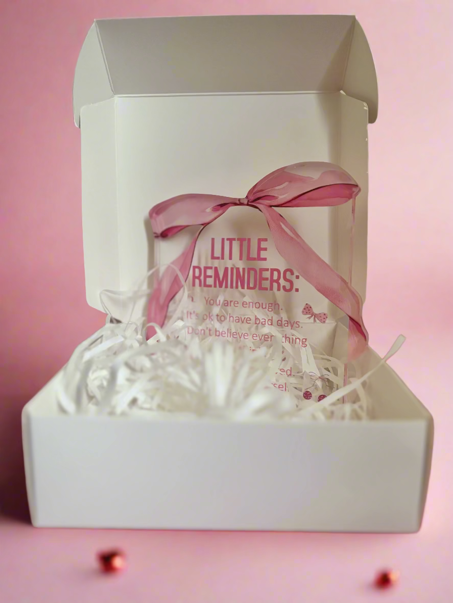 White box with a pink bow and 'Little Reminders' text on a pink background