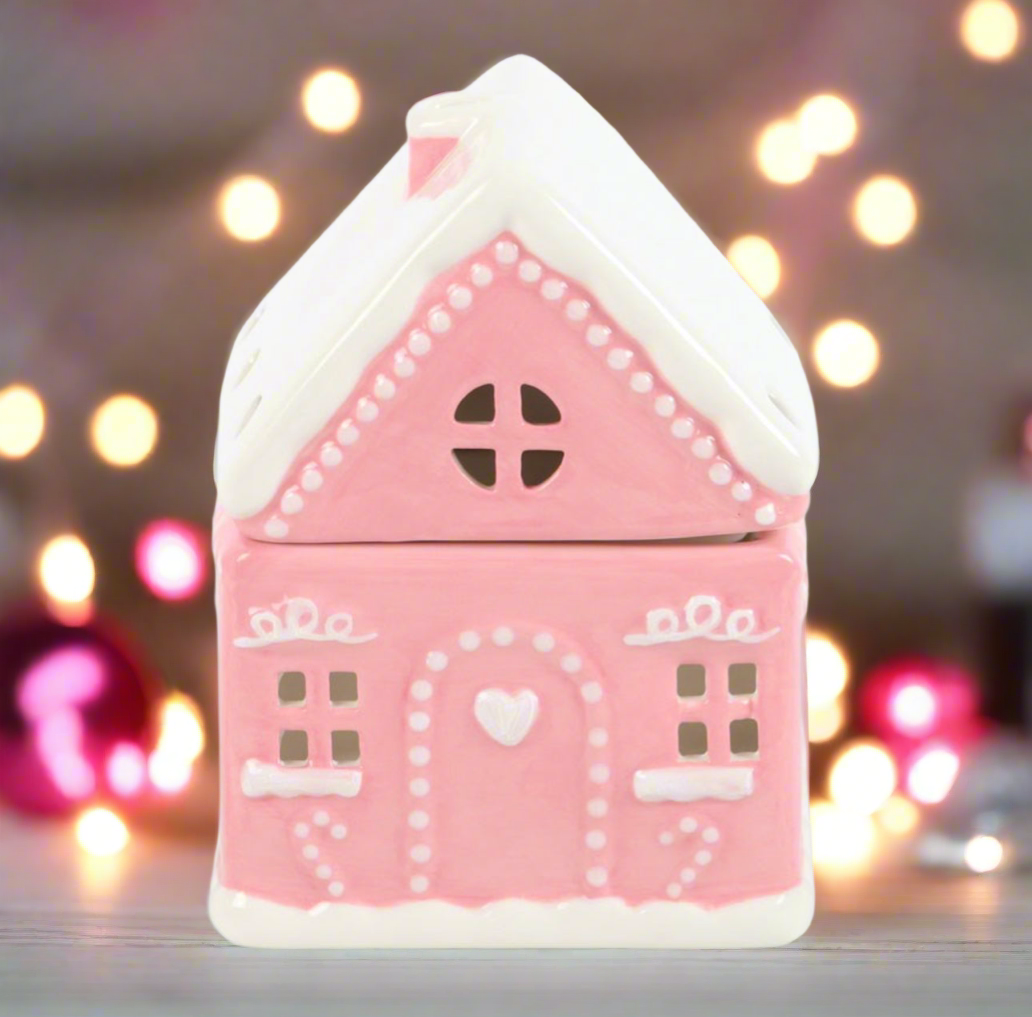 Pink gingerbread house-shaped light with a blurred festive background