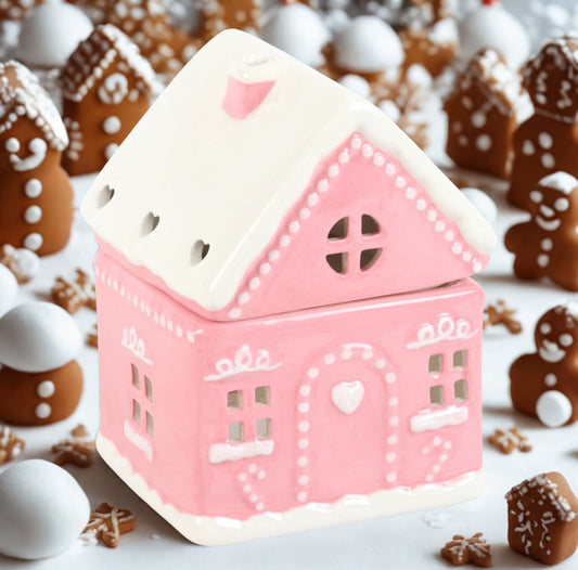 Pink gingerbread house-shaped container with decorative elements on a snowy background with gingerbread men.