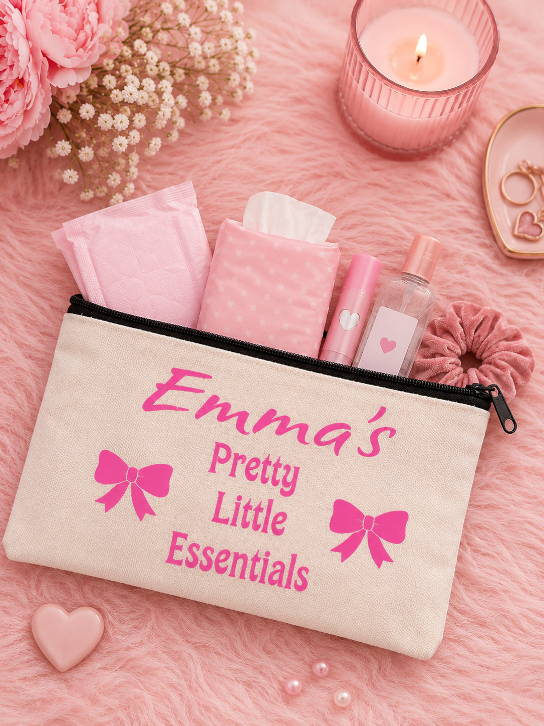 Personalized makeup bag labeled 'Emma's Pretty Little Essentials' with cosmetic items on a pink background.