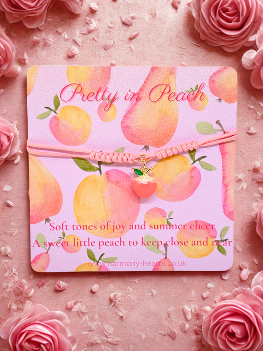Peach charm bracelet on a branded card with peach design and text on a pink floral background