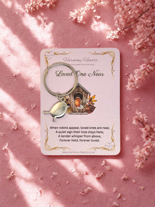Robin Keychain with card on pink background with floral elements