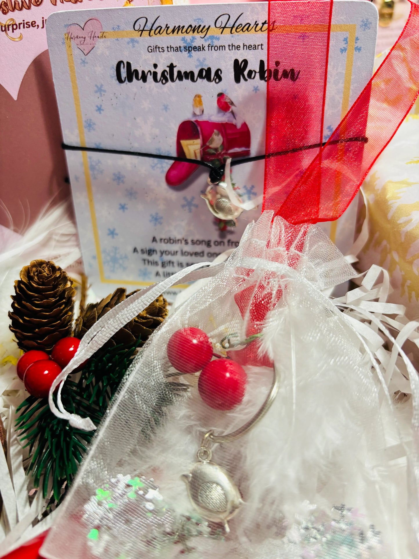 Christmas-themed robin bracelet with red berries and a card in the background