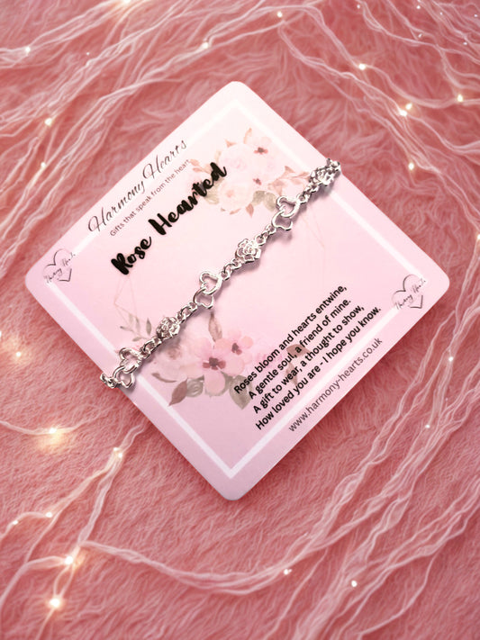 Silver bracelet on a 'Harmony Hearts' card with a pink floral design on a textured pink background.
