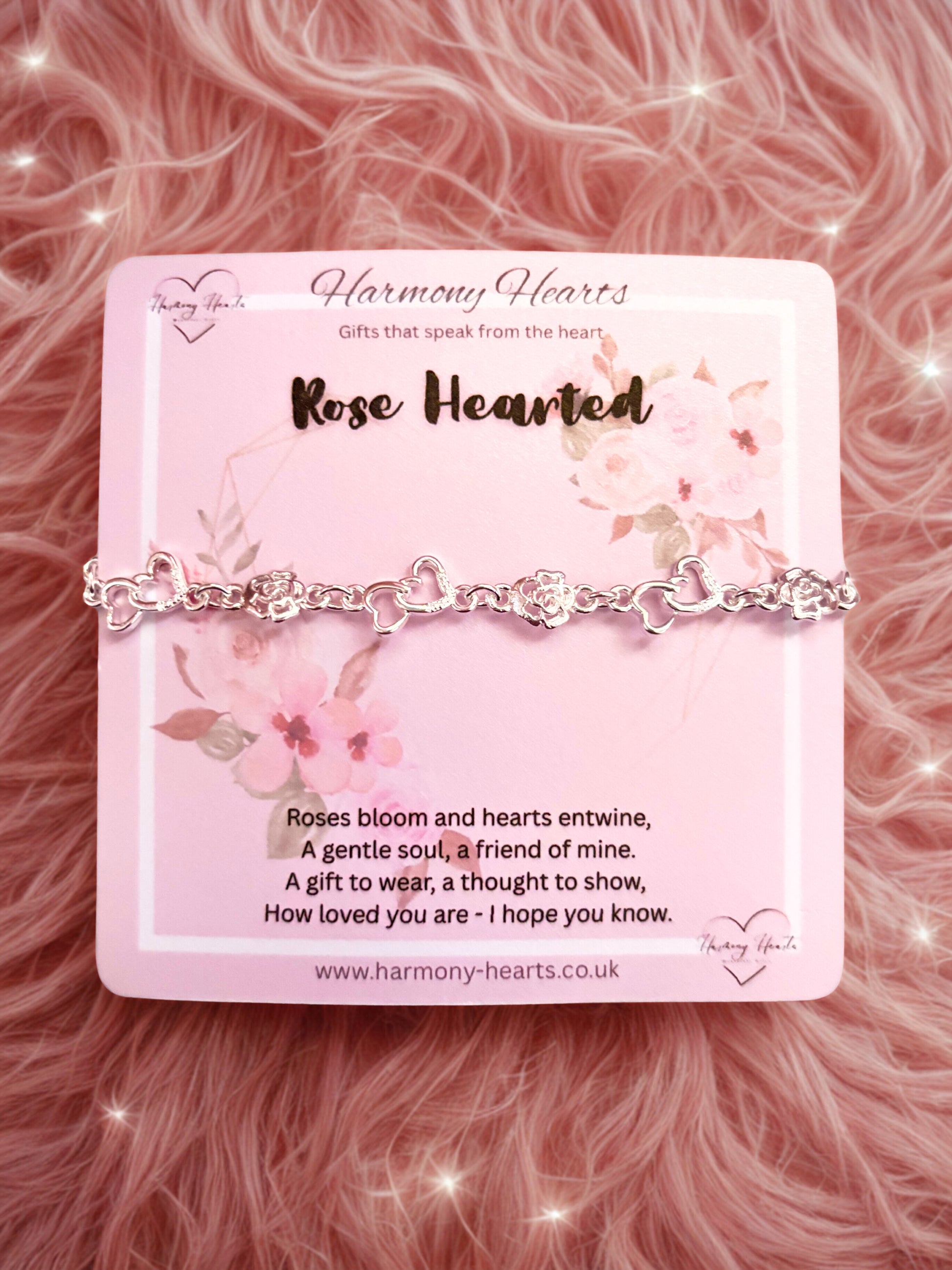 Bracelet on a pink card with floral design and text on a pink fluffy background