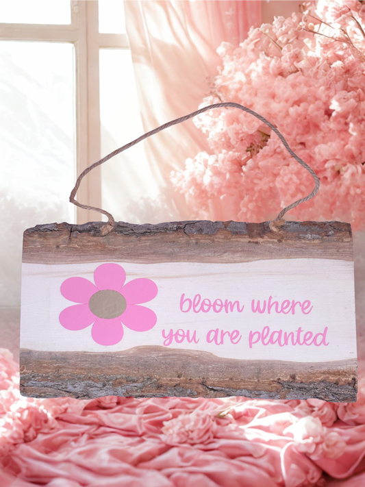 Rustic wood sign with pink text Bloom where you are planted and a pink flower