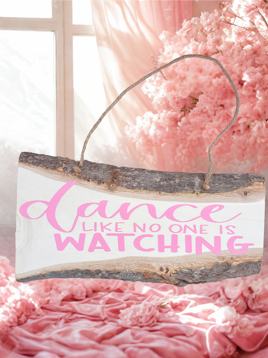 Decorative sign with 'dance like no one is watching' text on a pink floral background