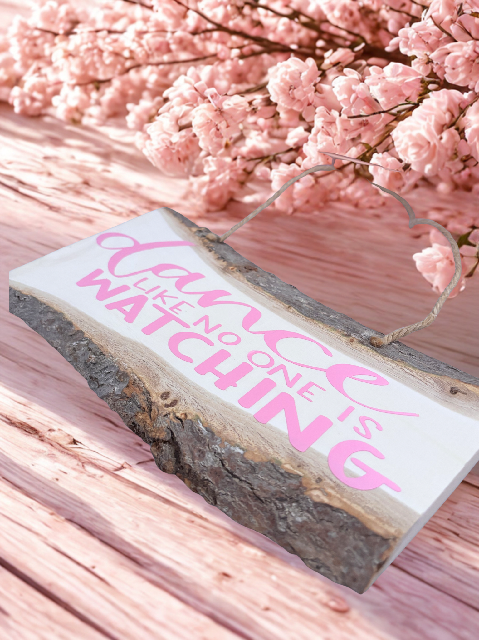 Wooden sign with 'Dance Like No one is watching' text on a pink floral background